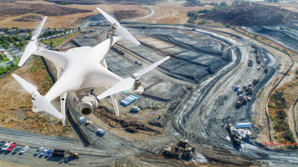 Unmanned Aircraft System (UAV) Quadcopter Drone In The Air Over Construction Site. Unmanned Aircraft System (UAV) Quadcopter Drone In The Air Over Construction Site.